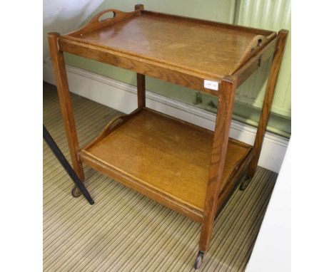 AN UNUSUAL PROBABLE 1930'S OAK FINISHED TWO TIER SERVING TABLE, each having twin handled pull out tray, the stand folding fla