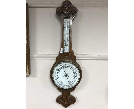 A carved oak aneroid barometer
