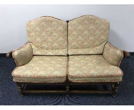 A two seater Ercol settee in multi coloured print 