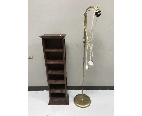 A contemporary CD rack and an adjustable brass standard lamp 