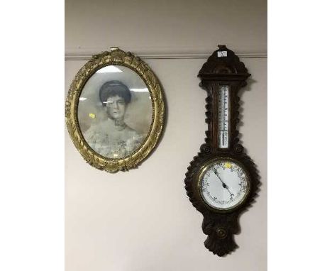 A heavily carved oak cased barometer and an antiquarian gilt framed portrait 