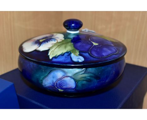 A BOXED MOORCROFT POTTERY 'BLUE PANSY' COVERED BOWL, of shallow squat form, having tube lined blue and purple flowers with  g