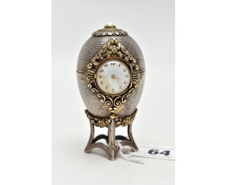 A 'ST JAMES HOUSE COMPANY' SILVER EASTER EGG CLOCK,  featuring a small round clock with a white dial, Arabic numerals, encase