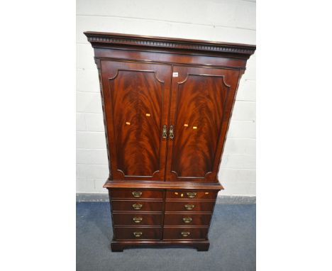 A MODERN MAHOGANY TV CABINET, top section with one adjustable shelf and a single drawer, base enclosing two drawers and a sli