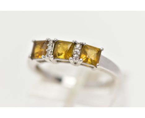 A 9CT WHITE GOLD GEM SET RING, designed with a row of three square yellowish/green stones assessed as Sphene, interspaced wit