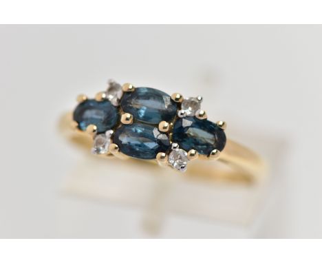 A 9CT GOLD SAPPHIRE AND TOPAZ RING, set with four oval cut blue sapphires, each in a four claw yellow gold setting, with four