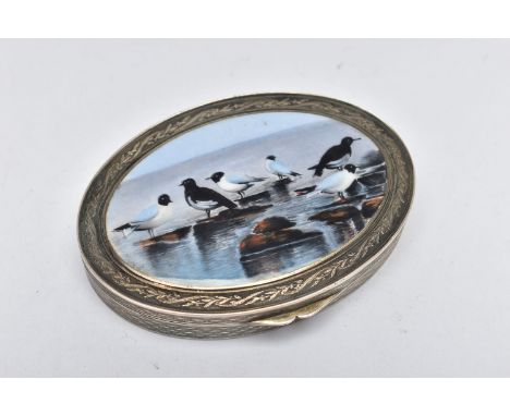 A WHITE METAL HINGED TRINKET BOX, of an oval form, depicting seagulls on rocks to the cover, engine turned pattern with flora