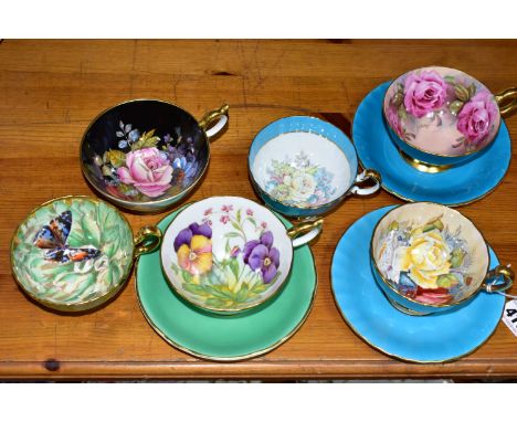 SIX AYNSLEY CABINET CUPS AND THREE SAUCERS, comprising a green cup and saucer, the interior of the cup decorated with pansies