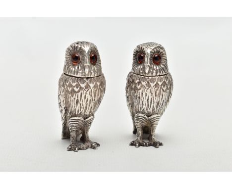 A PAIR OF SILVER NOVELTY OWL PEPPERETTES, each realistically textured with feathers, and both set with two orange glass eyes,