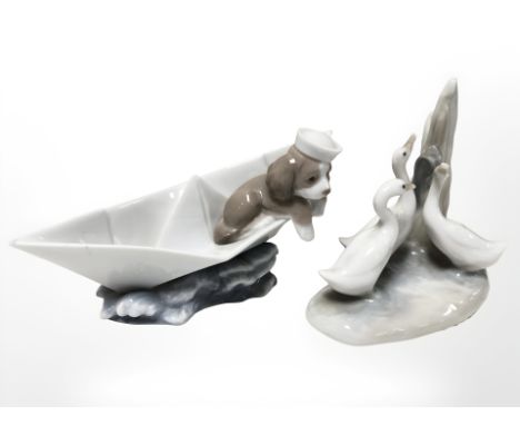 A Lladro figure of a puppy in a boat, numbered 6642 and a further Nao group of three swans 