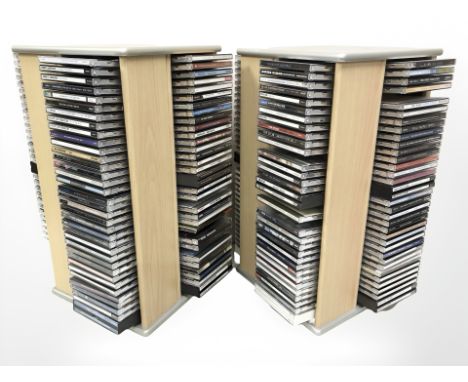 Two revolving CD towers containing assorted CDs including Bob Dylan, Stevie Ray Vaughan, Neil Young, The Beatles, Pink Floyd,