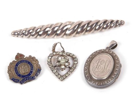 A mixed lot to include a white metal hinged locket, white metal paste set heart pendant, Suffolk Regiment silver and enamel b