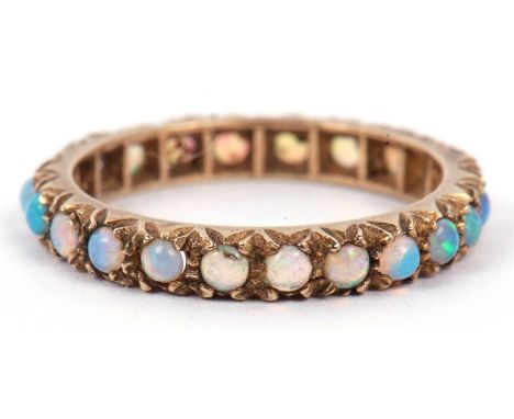 A vintage opal set full eternity ring featuring small round cabochon cut opals