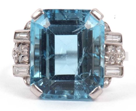 A precious metal aquamarine, 14.10 x 11.70 x 7.60 mm, and diamond ring, the step cut aquamarine with two baguette diamonds on