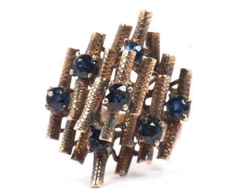 A designer ring, a tier design of engraved ridge bars highlighted between with small dark blue stones, stamped 18k, size K/L