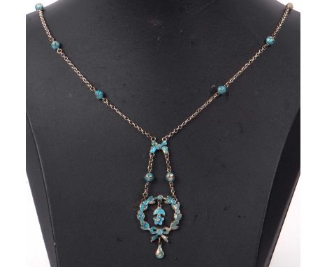 A vintage enamel and white metal necklace with an enamel open work garland with floral dropper, enamel decorated ribbon and b