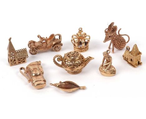 A group of eight 9ct gold charms to include a golf bag and clubs, vintage car, teapot, mermaid, mouse together with an enamel