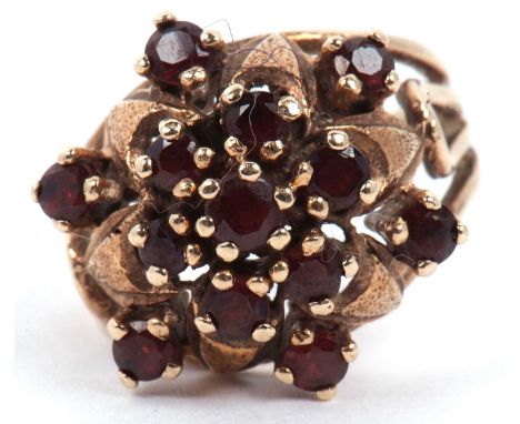 Garnet set cluster dress ring raised between split shoulders, marks rubbed, tested for 9ct gold, g/w 5.3 gms, size M