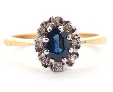 18ct gold sapphire and diamond cluster ring, the oval cut sapphire raised above a small diamond surround, size M