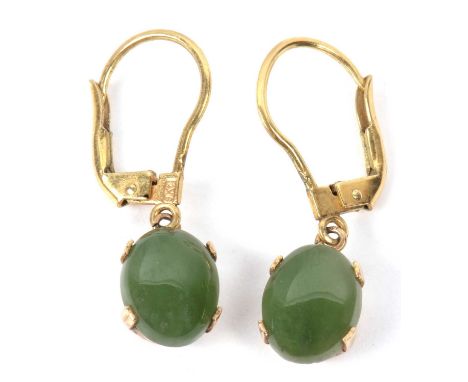 A pair of modern jade set earrings, oval cabochon cut jade stones, claw set in 9kt stamped mounts and fittings