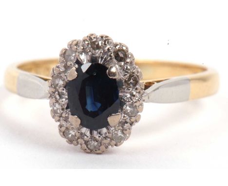 18ct stamped blue stone and diamond cluster ring, the oval centre stone within a small round illusion set surround, size O