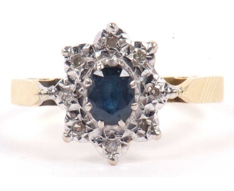 18ct gold sapphire and diamond cluster ring centering an oval cut faceted sapphire of 5 x 4 mm, raised above a small single c