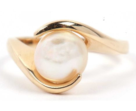 A modern pearl single stone ring set between crossover angular shoulders, stamped 14k, size M