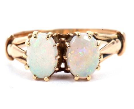 Opal two stone ring featuring two oval cabochon cut opals individually multi claw set and raised between split shoulders, sta