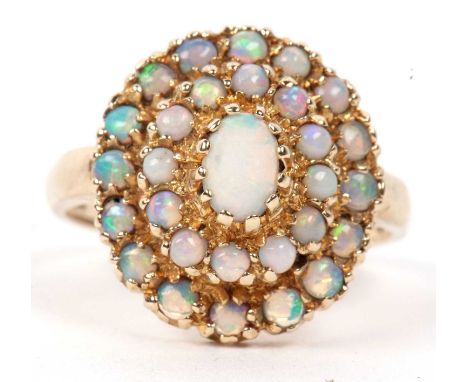 9ct opal cluster ring, the central oval opal cabochon surrounded by two tiers of smaller round opal caboncons, all set in 9ct