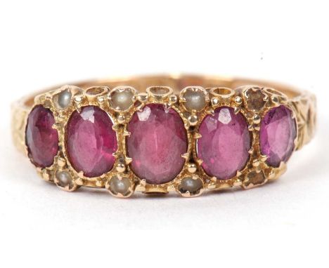 A Victorian 15ct gold ruby and seed pearl ring featuring five graduated oval faceted rubies highlighted between with six smal