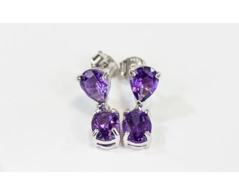 Amethyst Pair of Drop Earrings, each earring comprising an oval cut purple amethyst suspended below a pear cut, similar, set 