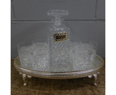 A drinks set on a metal tray with a decanter and six glasses 
