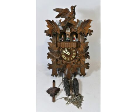 A Black Forest mechanical cuckoo clock, having musical carousel, with hand carved decoration, made in Germany, c1960s, 36cm x