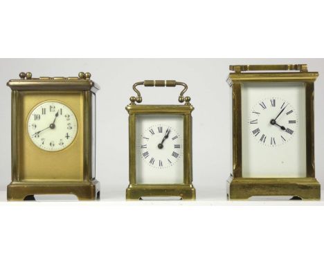 Three manual wind 8 day carriage clocks, brass cased, bevel edged glass panels, enamel dials with roman numerals. (3) 