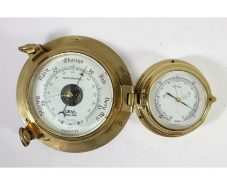 A brass ships bulkhead portal barometer, Yachtmaster by GRM of England, the barometer hinged, glass diameter 15cm together wi