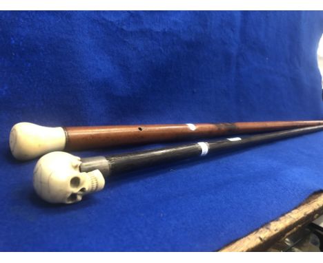 A silver handled walking stick bone skull top plus another