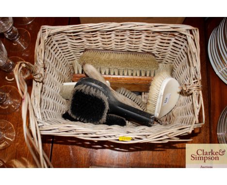 A wicker basket and contents of various vintage brushes 