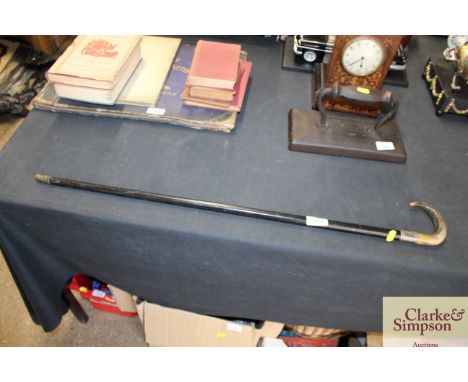 An ebonised walking stick with horn handle and silver mount 