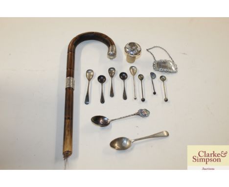 A box containing a silver mounted umbrella handle; various silver and white metal spoons; decanter label etc.