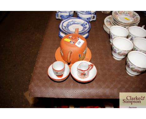 A terracotta teapot on stand and four pieces of Japanese tea ware 