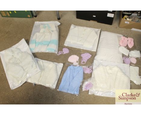 A box of vintage knitted and crochet clothing items for baby/ doll; also a woollen shawl 