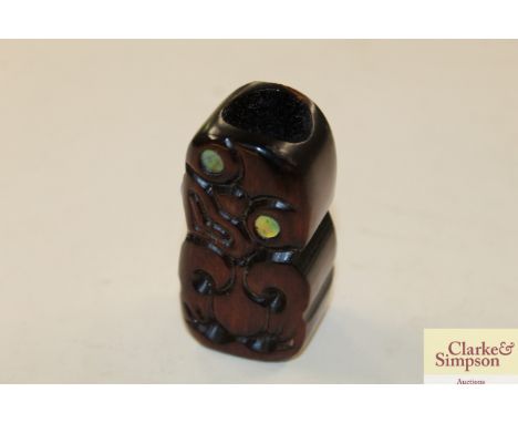 A Maori carved wooden item with mother of pearl eyes 