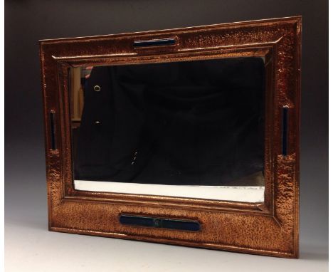 An Arts and Crafts beaten copper rectangular mirror, set with elongated oval raised enamel bosses, 57cm x 45.5cm, c.1920