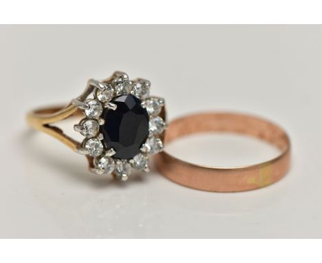 TWO 9CT GOLD RINGS, the first an oval cluster ring, centring on a four claw set, oval cut deep blue sapphire, in a surround o