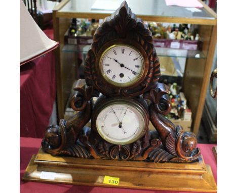 		A late Victorian walnut mantle clock, barometer, and thermometer, the case carved with wreath and dolphins. 17 1/2' high (c