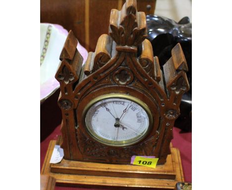 		A Victorian aneroid barometer in a walnut 'gothic' architectural case. 11 1/2' high. Glass cracked