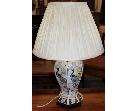 		A ceramic table lamp decorated with peafowl