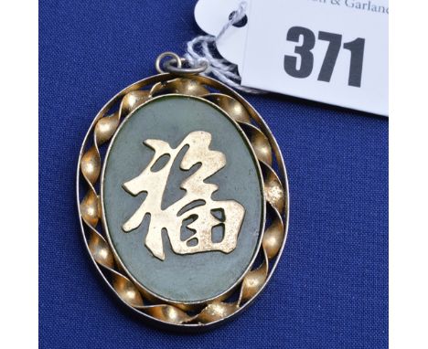 A jade coloured stone and yellow metal Chinese oval pendant with character design.