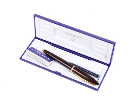 A boxed Waterman fountain pen. Having an 18ct gold nib and marbled red body