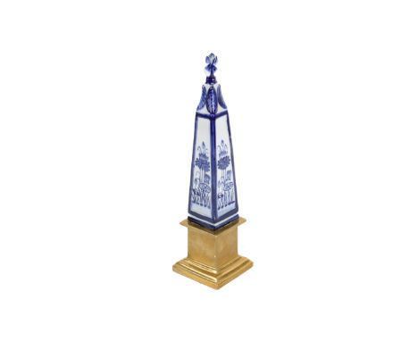 Blue and white ceramic obelisk raised on a brass stepped plinth. H36cm